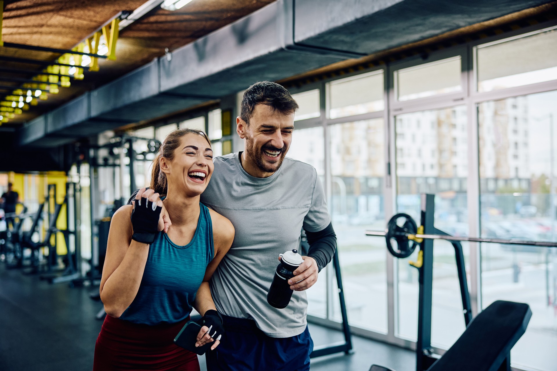 Cheerful athletic couple having sports training in a gym.